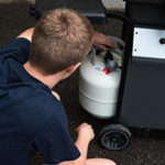 Checking propane tank under grill